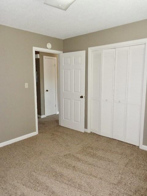 unfurnished bedroom featuring carpet floors and a closet