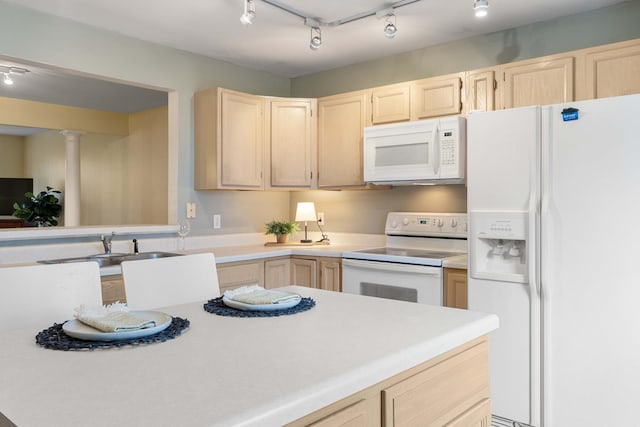 kitchen featuring sink, white appliances, rail lighting, light brown cabinetry, and ornate columns