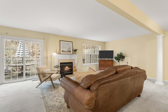 living room with light colored carpet, plenty of natural light, and decorative columns