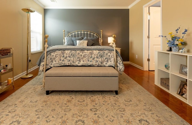 bedroom with ornamental molding and hardwood / wood-style floors