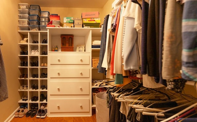 walk in closet with light hardwood / wood-style floors