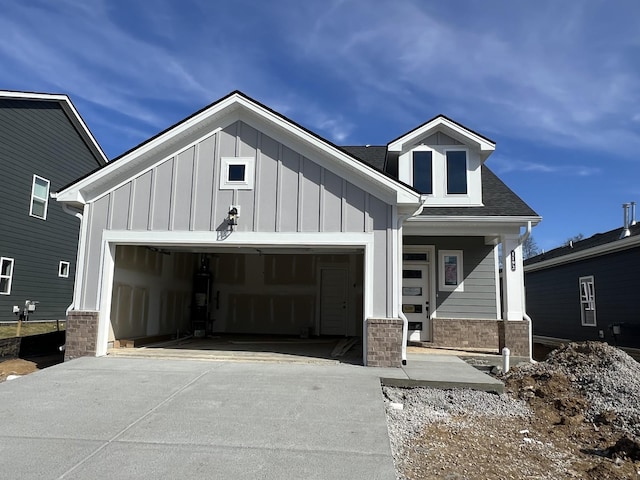 view of front facade featuring an attached garage, a shingled roof, board and batten siding, and concrete driveway