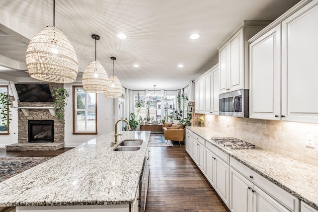 kitchen featuring stainless steel appliances, pendant lighting, a large island, and sink