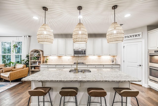 kitchen with sink, an island with sink, and appliances with stainless steel finishes