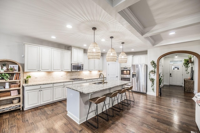 kitchen featuring pendant lighting, an island with sink, white cabinets, and appliances with stainless steel finishes