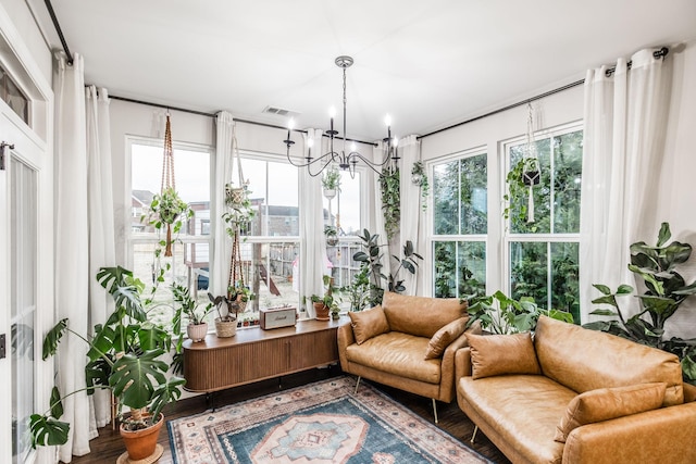 sunroom with a healthy amount of sunlight and a notable chandelier