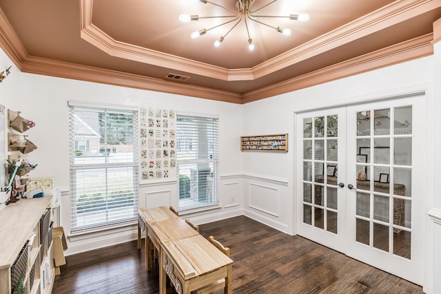 unfurnished dining area featuring french doors, crown molding, dark wood-type flooring, and a tray ceiling