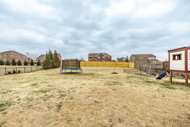 view of yard with a playground and a trampoline