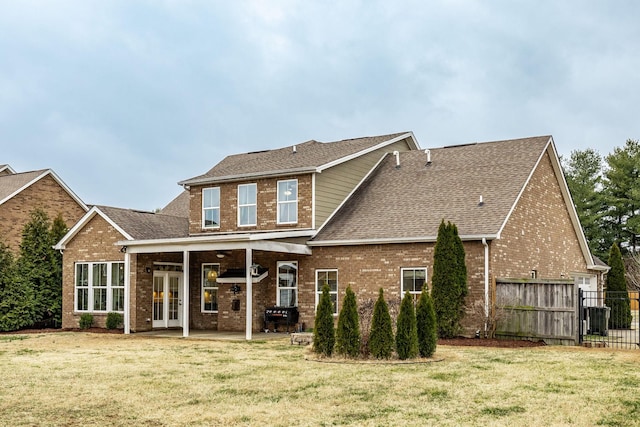 back of property with a patio, a yard, and french doors