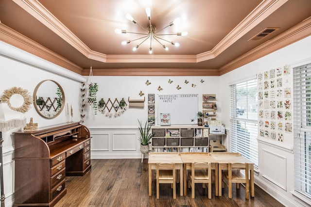 dining area with crown molding, dark wood-type flooring, a raised ceiling, and a chandelier