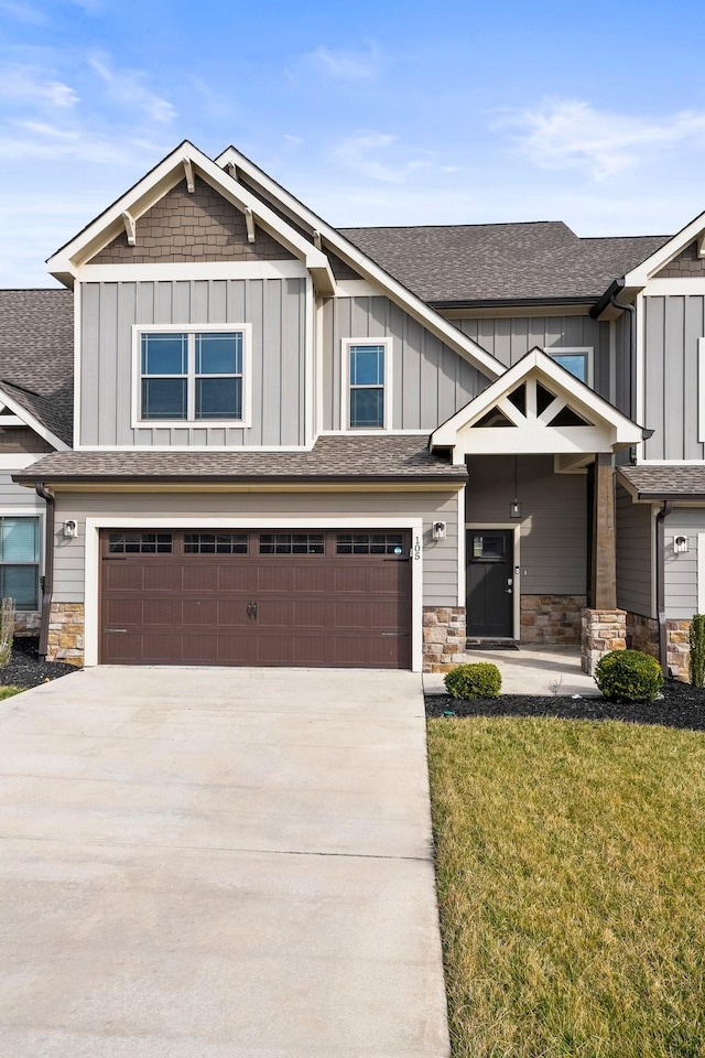 craftsman house with a garage and a front lawn