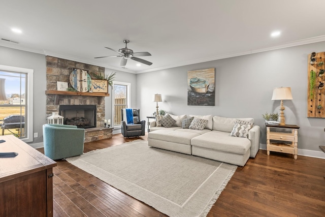 living room with ornamental molding, dark hardwood / wood-style floors, and a stone fireplace