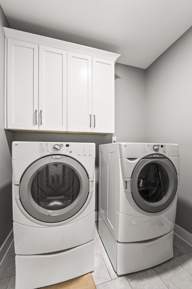 clothes washing area featuring cabinets and washing machine and dryer