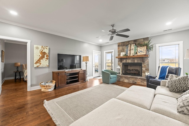 living room featuring ornamental molding, dark hardwood / wood-style floors, ceiling fan, and a fireplace