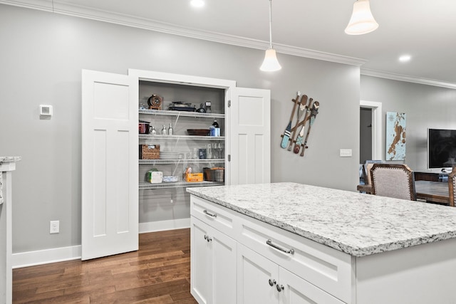 kitchen with crown molding, dark wood-type flooring, hanging light fixtures, white cabinets, and a kitchen island