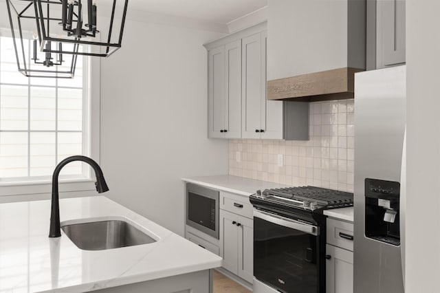 kitchen featuring sink, decorative light fixtures, custom range hood, stainless steel appliances, and decorative backsplash