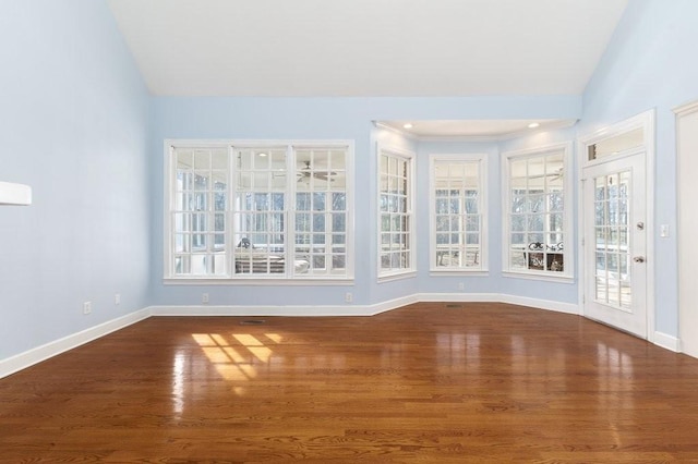 unfurnished sunroom featuring vaulted ceiling