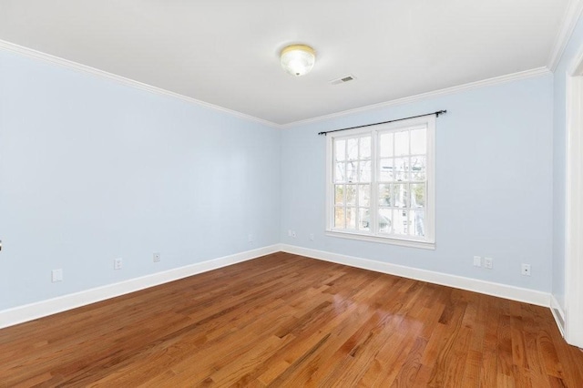 empty room with crown molding and hardwood / wood-style flooring