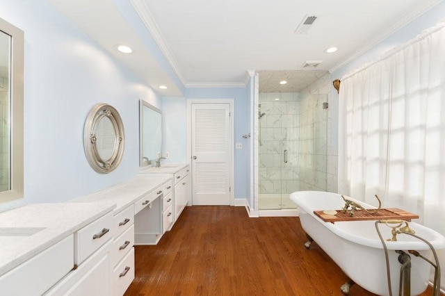 bathroom featuring hardwood / wood-style flooring, crown molding, vanity, and plus walk in shower