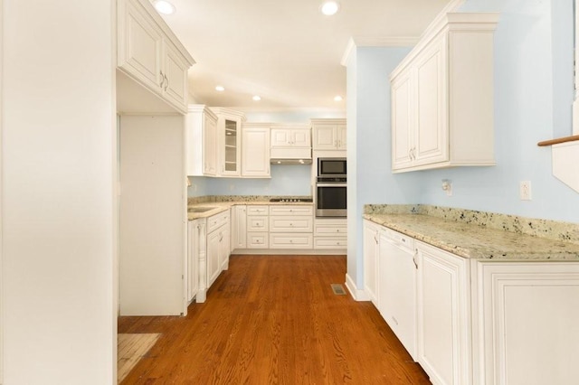 kitchen with dark wood-type flooring, sink, light stone counters, white cabinetry, and appliances with stainless steel finishes