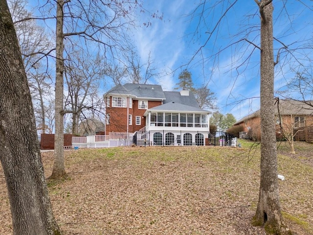 rear view of house featuring a sunroom