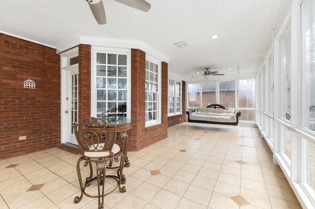 unfurnished sunroom featuring ceiling fan