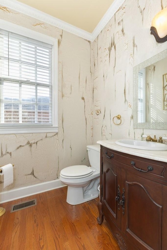 bathroom with ornamental molding, toilet, wood-type flooring, and vanity