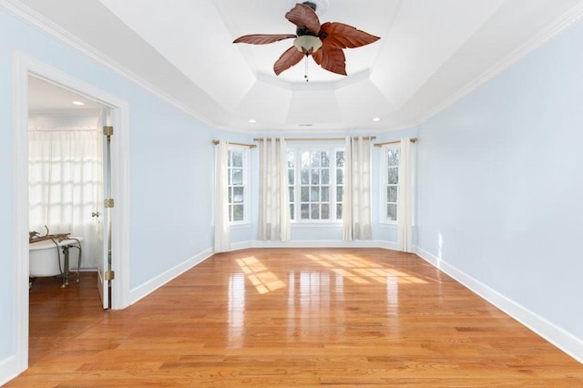 unfurnished room featuring crown molding, light hardwood / wood-style floors, a raised ceiling, and ceiling fan