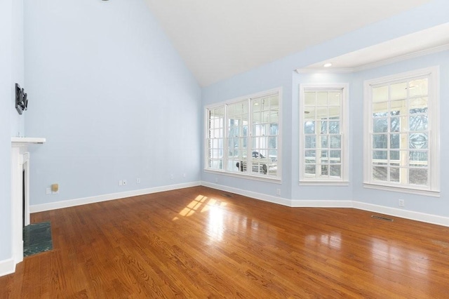 unfurnished living room with lofted ceiling, plenty of natural light, and wood-type flooring