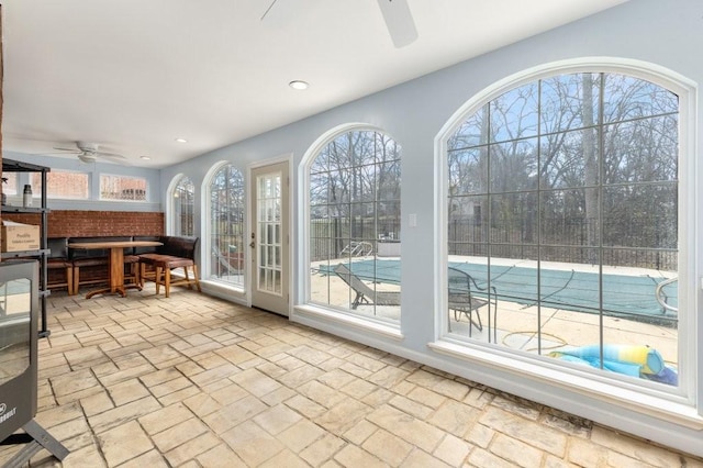 sunroom / solarium featuring ceiling fan