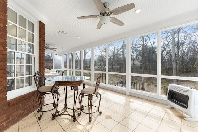 sunroom with heating unit and ceiling fan