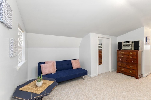 living area featuring light colored carpet and vaulted ceiling