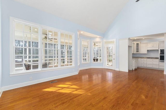 unfurnished living room featuring ceiling fan, wood-type flooring, and high vaulted ceiling