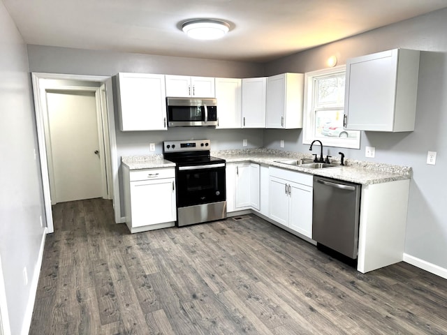 kitchen with white cabinetry, appliances with stainless steel finishes, sink, and dark hardwood / wood-style flooring