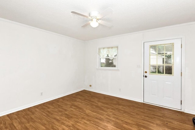 empty room with dark hardwood / wood-style flooring, ceiling fan, crown molding, and a textured ceiling