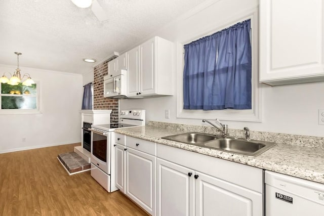 kitchen with sink, decorative light fixtures, light hardwood / wood-style flooring, white appliances, and white cabinets