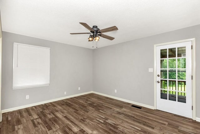 spare room featuring ceiling fan, dark hardwood / wood-style floors, and a textured ceiling