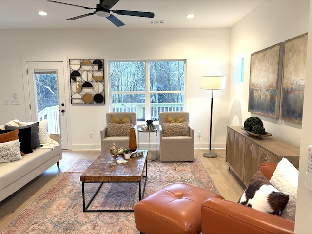 living room with ceiling fan and light hardwood / wood-style flooring