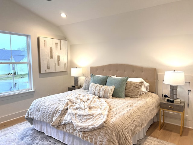 bedroom with hardwood / wood-style floors and vaulted ceiling