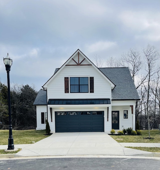 modern farmhouse featuring a garage and a front lawn