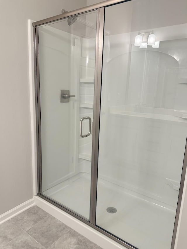 bathroom with a shower with shower door and tile patterned flooring