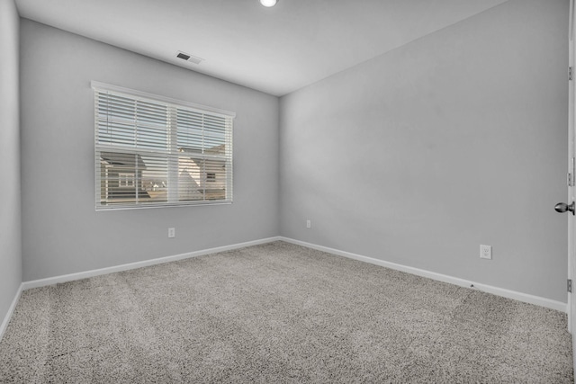 carpeted spare room featuring visible vents and baseboards