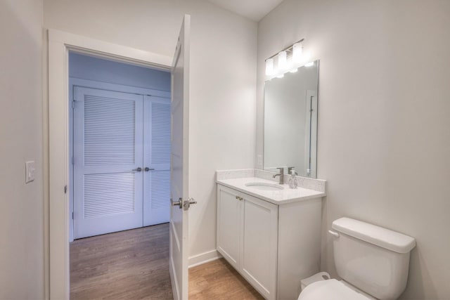 bathroom featuring vanity, hardwood / wood-style flooring, and toilet