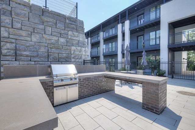 view of patio featuring an outdoor kitchen and a grill