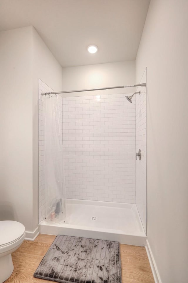 bathroom featuring hardwood / wood-style floors, toilet, and a shower with shower curtain