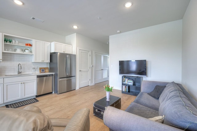 living room with sink and light hardwood / wood-style floors