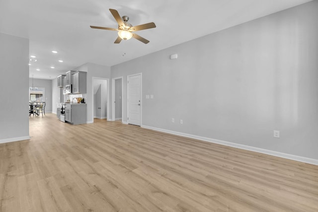 unfurnished living room featuring ceiling fan and light hardwood / wood-style floors