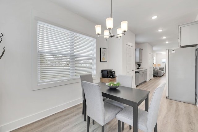 dining area with a chandelier and light hardwood / wood-style flooring