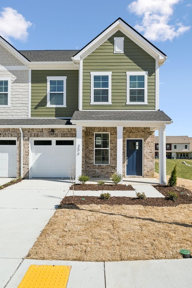 view of front of property featuring covered porch, concrete driveway, an attached garage, a shingled roof, and brick siding