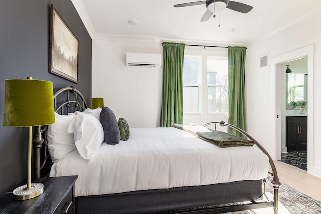 bedroom featuring connected bathroom, hardwood / wood-style floors, ceiling fan, crown molding, and a wall unit AC